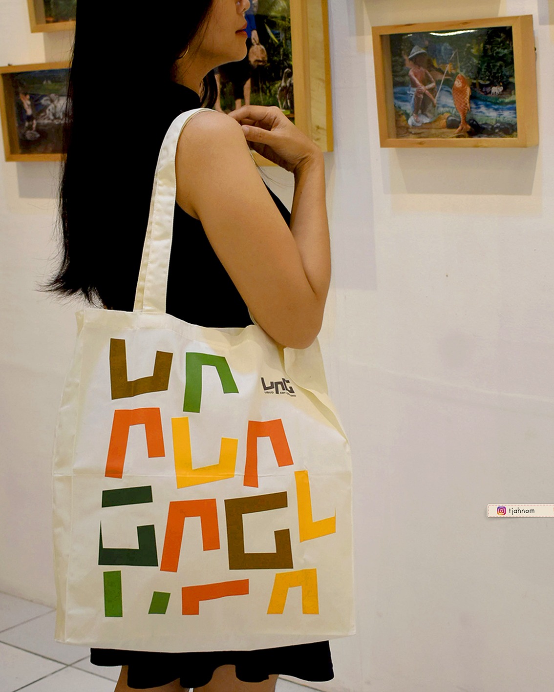 Dokumentasi kehadiran tote bag blacu custom NOM Souvenir di Ubud Art Ground, menampilkan pengunjung pameran internasional menenteng tas dengan desain logo full color yang estetik